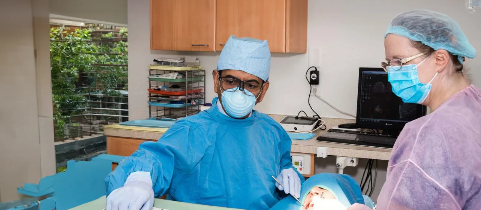 Dr. Patel performing a dental implant procedure with his clinical team